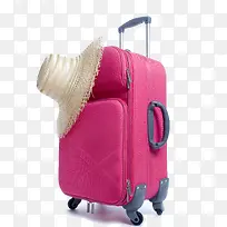 粉红色行李箱和草帽